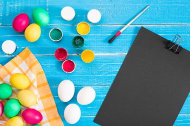 Mavi rustik ahşap arka plan üzerinde renkli Paskalya yumurtaları