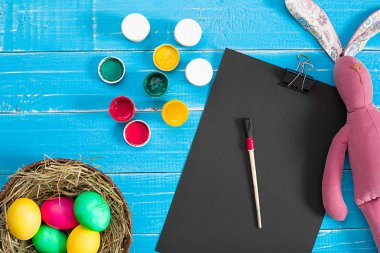 Yuvaya mavi ahşap tahta üzerinde renkli Paskalya yortusu yumurta.