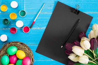 Renkli Paskalya yumurtaları ve Lale mavi rustik ahşap arka plan üzerinde