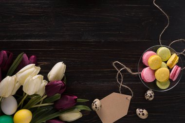 Paskalya yumurtaları ve laleler koyu ahşap plakalar üzerinde