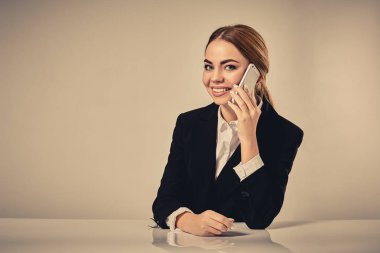 siyah bir takım elbise giymiş çekici esmer kadın oturuyor