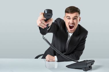 genç adam ofiste otururken telefon numarasını çevirir