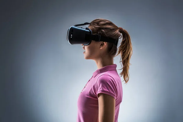 Giovane donna che indossa cuffie realtà virtuale in studio. Emozioni. Vista laterale — Foto Stock