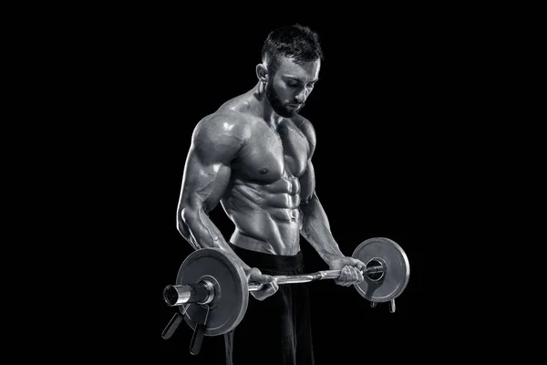 Uomo muscolare sollevamento pesi su sfondo scuro — Foto Stock
