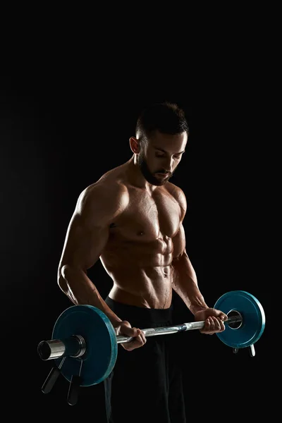 Muscular hombre levantamiento de pesas sobre fondo oscuro —  Fotos de Stock