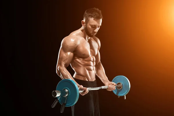 Muscular man lifting weights over dark background — Stock Photo, Image