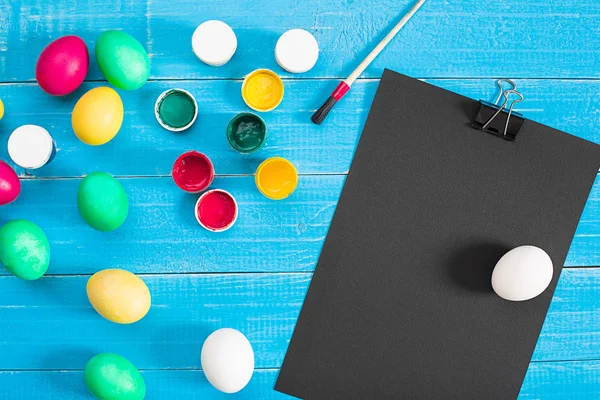 Mavi rustik ahşap arka plan üzerinde renkli Paskalya yumurtaları