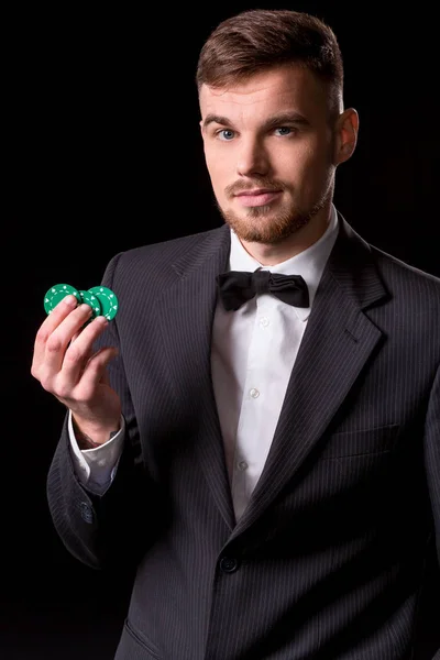Чоловік у костюмі позує з фішками для азартних ігор — стокове фото