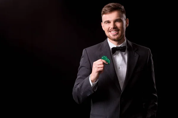 Чоловік у костюмі позує з фішками для азартних ігор — стокове фото