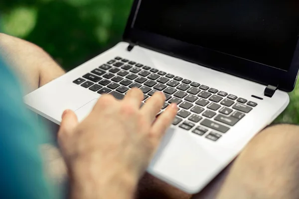 Ovanifrån manliga händer använder bärbara utomhus i urban miljö medan du skriver på tangentbord, affärsman frilansare arbetar på dator. — Stockfoto