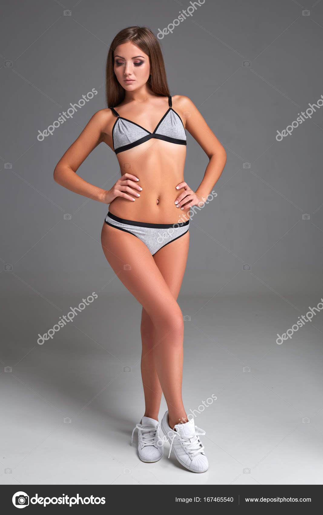 Beautiful girl in sports underwear isolated on gray background