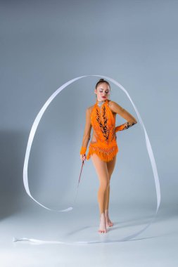 mavi bir arka Beyaz kurdele ile jimnastik dansı yapan genç