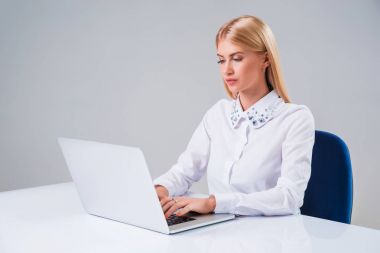 Dizüstü bilgisayarda çalışan genç iş kadını