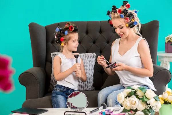 Anne ve kızı curlers içinde kanepede stüdyoda makyaj ve iyi eğlenceler