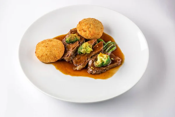 Μάγουλα βόειο κρέας σε σάλτσα με μπρόκολο και τα πράσινα φασόλια σε ένα άσπρο πιάτο. — Φωτογραφία Αρχείου