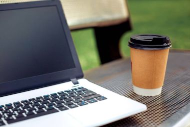 Mockup görüntü boş siyah perde ve kahve fincanı doğa park açık metal bankta ile dizüstü
