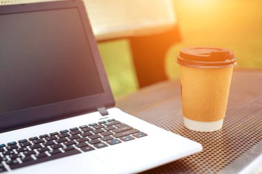 Mockup görüntü boş siyah perde ve kahve fincanı doğa park açık metal bankta ile dizüstü