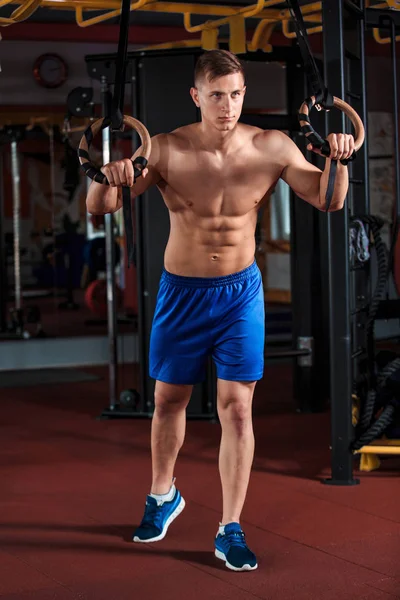 체조 링을 사용 하 여 체육관에서 운동 하는 동안 젊은 남자의 초상화 — 스톡 사진