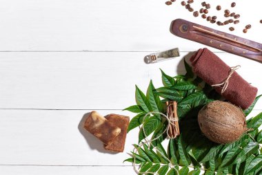 Kahve çekirdekleri, kahverengi havlu, Hindistan cevizi ve Beyaz ahşap zemin üzerine yeşil yaprakları ile doğal el yapımı sabunlar