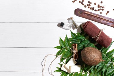 Kahve çekirdekleri, kahverengi havlu, Hindistan cevizi ve Beyaz ahşap zemin üzerine yeşil yaprakları ile doğal el yapımı sabunlar