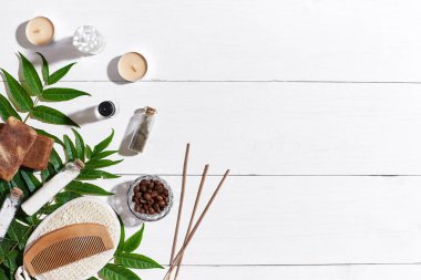 Kahve çekirdekleri, deniz tuzu, lif kabağı, kahverengi havlu ve Beyaz ahşap zemin üzerine yeşil yaprakları ile doğal el yapımı sabunlar