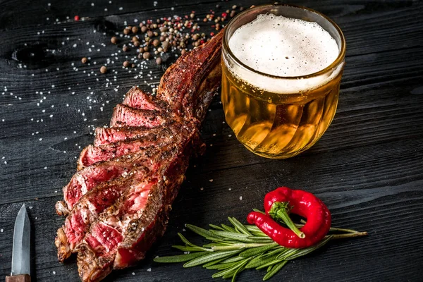 Bife grelhado temperado com especiarias e ervas frescas servidas com caneca de cerveja, pimenta vermelha fresca. — Fotografia de Stock