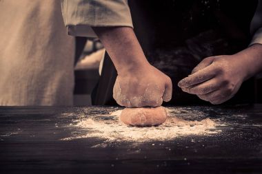 Şef hamur makarna için ahşap bir masaya sağlar.