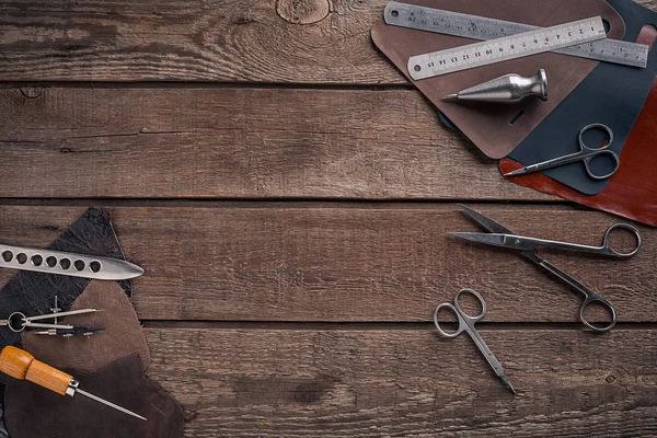 Leather craft or leather working. Leather working tools and cut out pieces of leather on work desk .