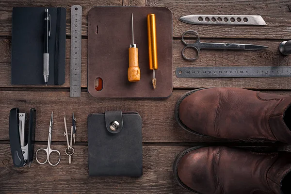 Kožené řemesla nebo kožené pracovní. Kožená pracovní nástroje a vystřižené kousky kůže na pracovní stůl . — Stock fotografie
