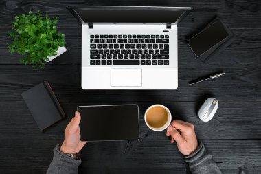 Bir dizüstü bilgisayarda yazarak erkek hipster siyah ahşap masaüstü üstten görünüm, eller