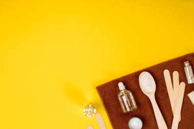 Spa ya da sağlık beyaz renk ayarında. Temel aroma yağı, havlu, Sarı zemin üzerine deniz tuzu ile şişe.