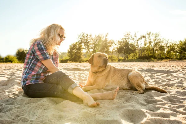 Genç kadın ile onun köpek sahilde