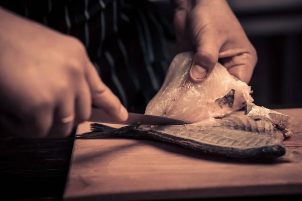 Chef cortando o peixe em uma placa — Fotografia de Stock
