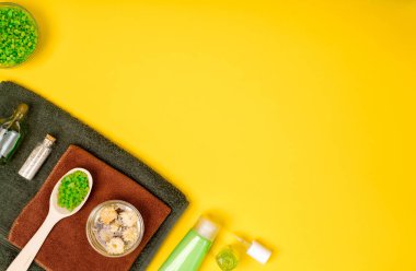 Spa ya da sağlık yeşil renk ayarında. Temel aroma yağı, havlu, Sarı zemin üzerine deniz tuzu ile şişe.