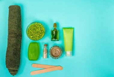 Spa set: sabun, maske, petrol, deniz tuzu ve havlu mavi zemin üzerine