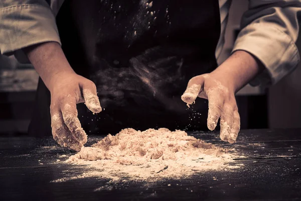 El chef hace masa para pasta en una mesa de madera —  Fotos de Stock