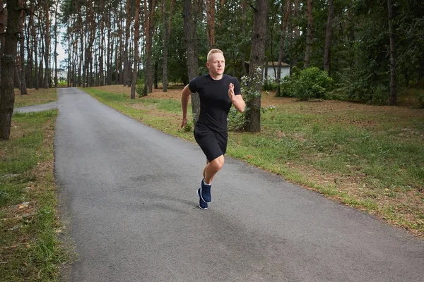 Joven atleta corriendo en el bosque — Foto de Stock
