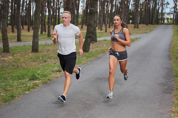 Pareja corriendo en el bosque — Foto de Stock