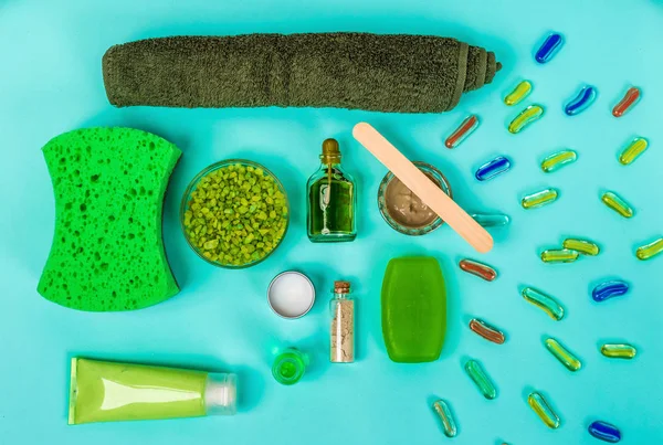 Spa set: sabun, maske, petrol, deniz tuzu ve havlu mavi zemin üzerine