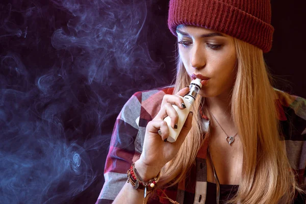 Young woman smoking electronic cigarette — Stock Photo, Image