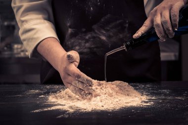 Şef hamur makarna için ahşap bir masaya sağlar.