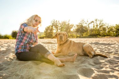 Genç kadın ile onun köpek sahilde
