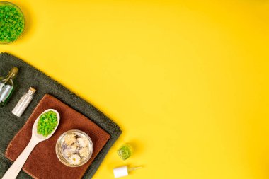 Spa ya da sağlık yeşil renk ayarında. Temel aroma yağı, havlu, Sarı zemin üzerine deniz tuzu ile şişe.