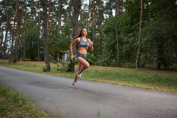 Junge Frau läuft im Stadtpark ins Freie — Stockfoto