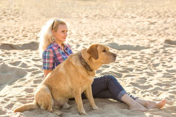 Genç kadın ile onun köpek sahilde