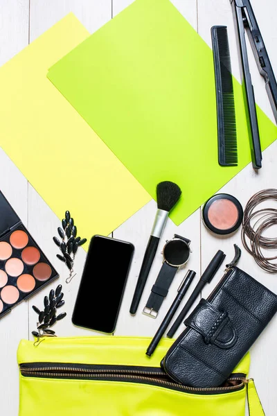 Cosmetica en womens accessoires viel uit de groene handtas op witte achtergrond. — Stockfoto