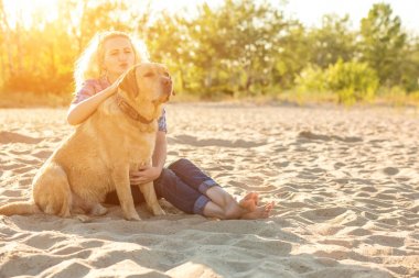 Onun köpeği kumsalda genç kadınla. Güneş parlaması