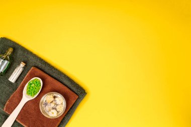 Spa ya da sağlık yeşil renk ayarında. Temel aroma yağı, havlu, Sarı zemin üzerine deniz tuzu ile şişe.