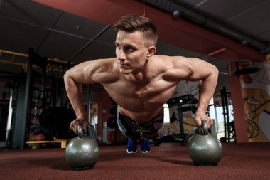 Dambılla şınav çeken bir adam.