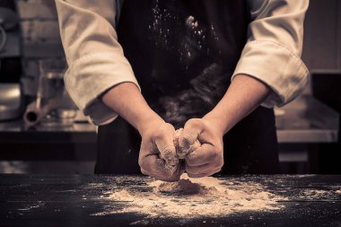 Şef hamur makarna için ahşap bir masaya sağlar.